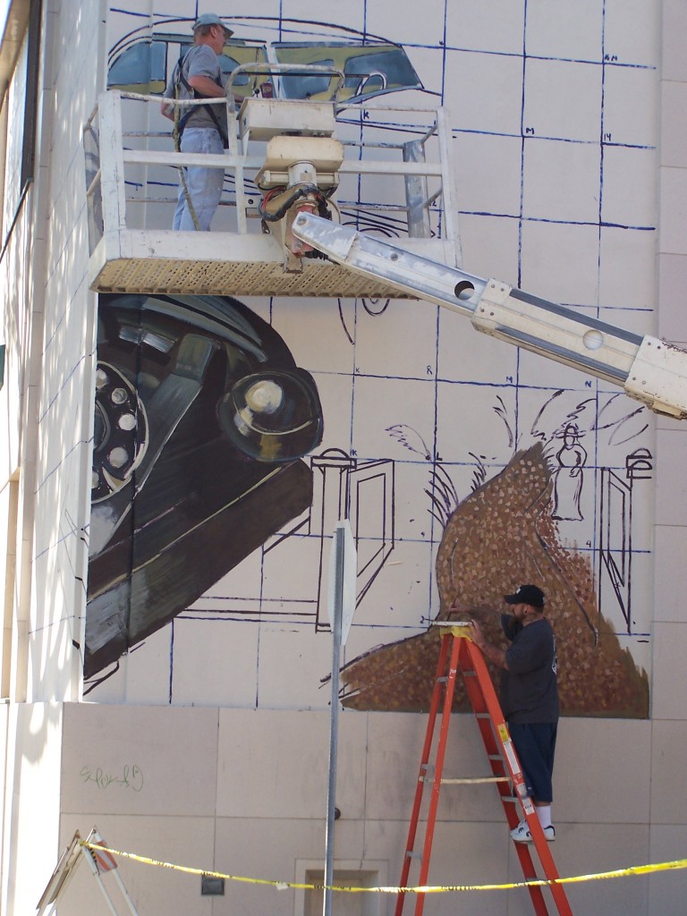 Day 3: Photograph of Tyler Kinnamen working on the Harriet Russell Strong section of the mural.