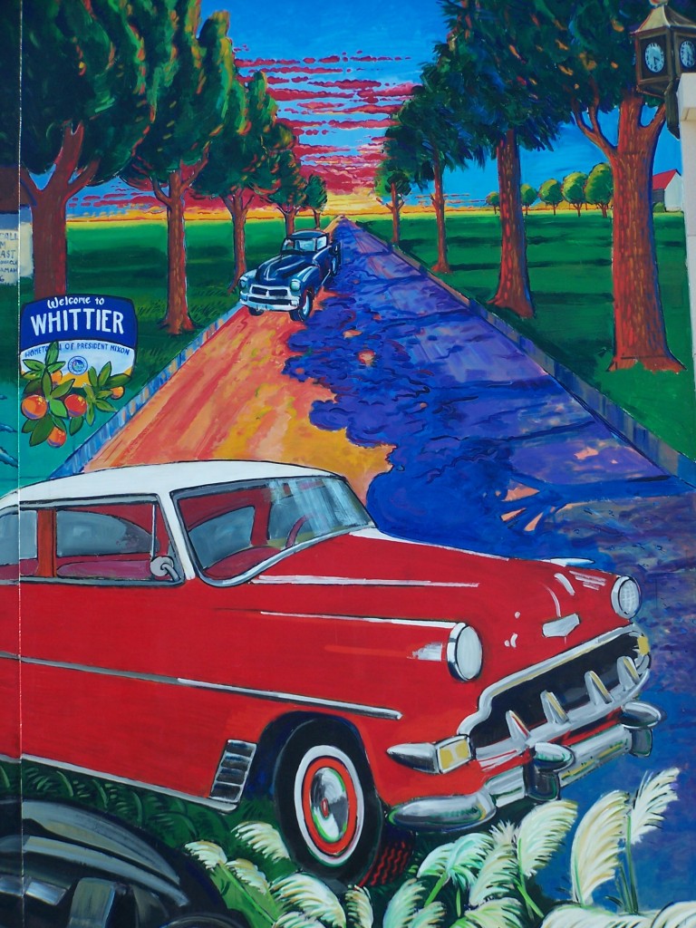 Finished mural: Photograph of close-up view of the Chevy car, Welcome to Whittier sign, Whittier Blvd., and the Village clock