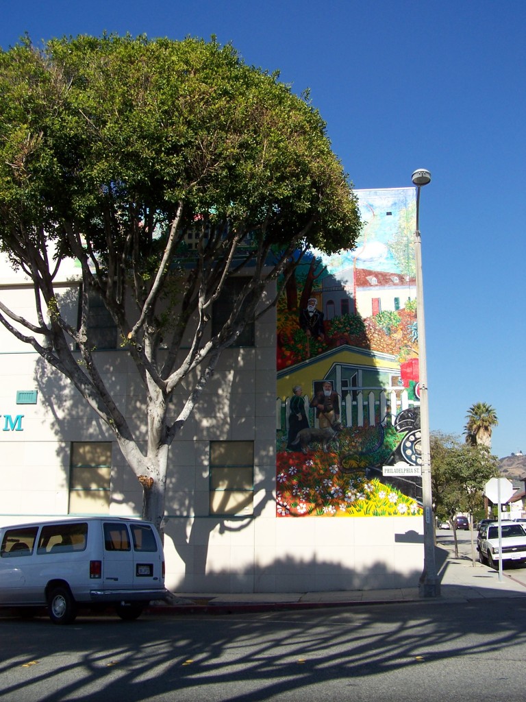 Finished mural: Photograph of entire mural section facing Philadelphia St. The Whittier statue and Carnegie library are mostly blocked by a Ficus tree.