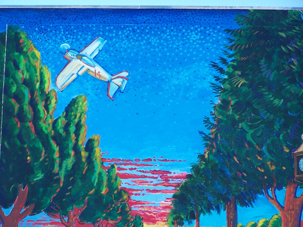 Finished mural: Photograph of the Whittier Blvd. section of the mural showing Bob Downey's #14 airplane in the sky above Whittier.