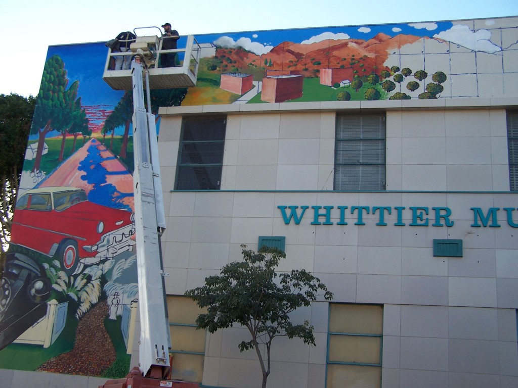 Day 8: Photograph of Dennis McGonagle and Tyler Kinnaman on the boom lift putting the finshing touches on the Whittier Blvd. section of the mural.