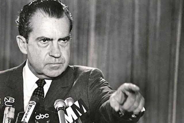 Black and white photograph of Richard Nixon at a press conference.  He is shown pointing at one of the reporters.