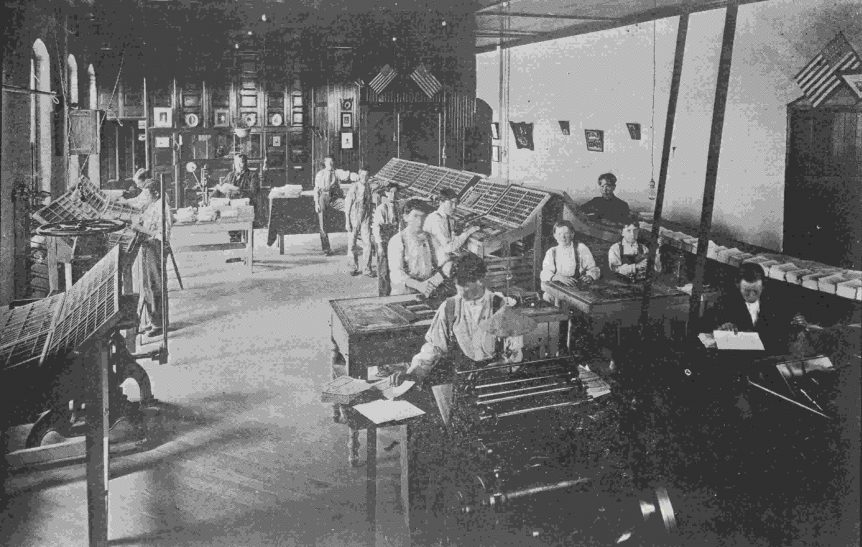 Photo from the 1906 Biennial Report of the Whittier State School showing the boys working setting type in the Print Shop.