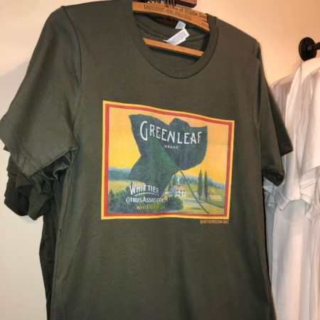 Photograph of an army green t-shirt. The shirt is unisex style with short sleeves. The Greenleaf Brand graphic is printed on the front of the shirt.