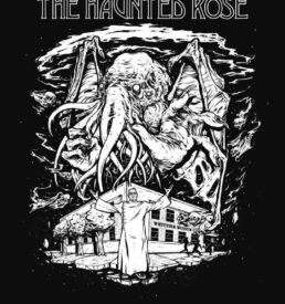 Photograph of the 2021 Haunted Rose graphic. T-shirt is short sleeved, black with a white graphic which shows a monster above the Whittier Museum. The Whittier Historical Society coat of arms is on the sleeve