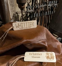Photograph of two thin, wood book marks. Text on first "Whittier Ye olde friendly towne" and text on second "Whittier Museum" and includes Whittier Historical Society coat of arms.