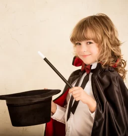 Promo photo of a little girl being a magician.