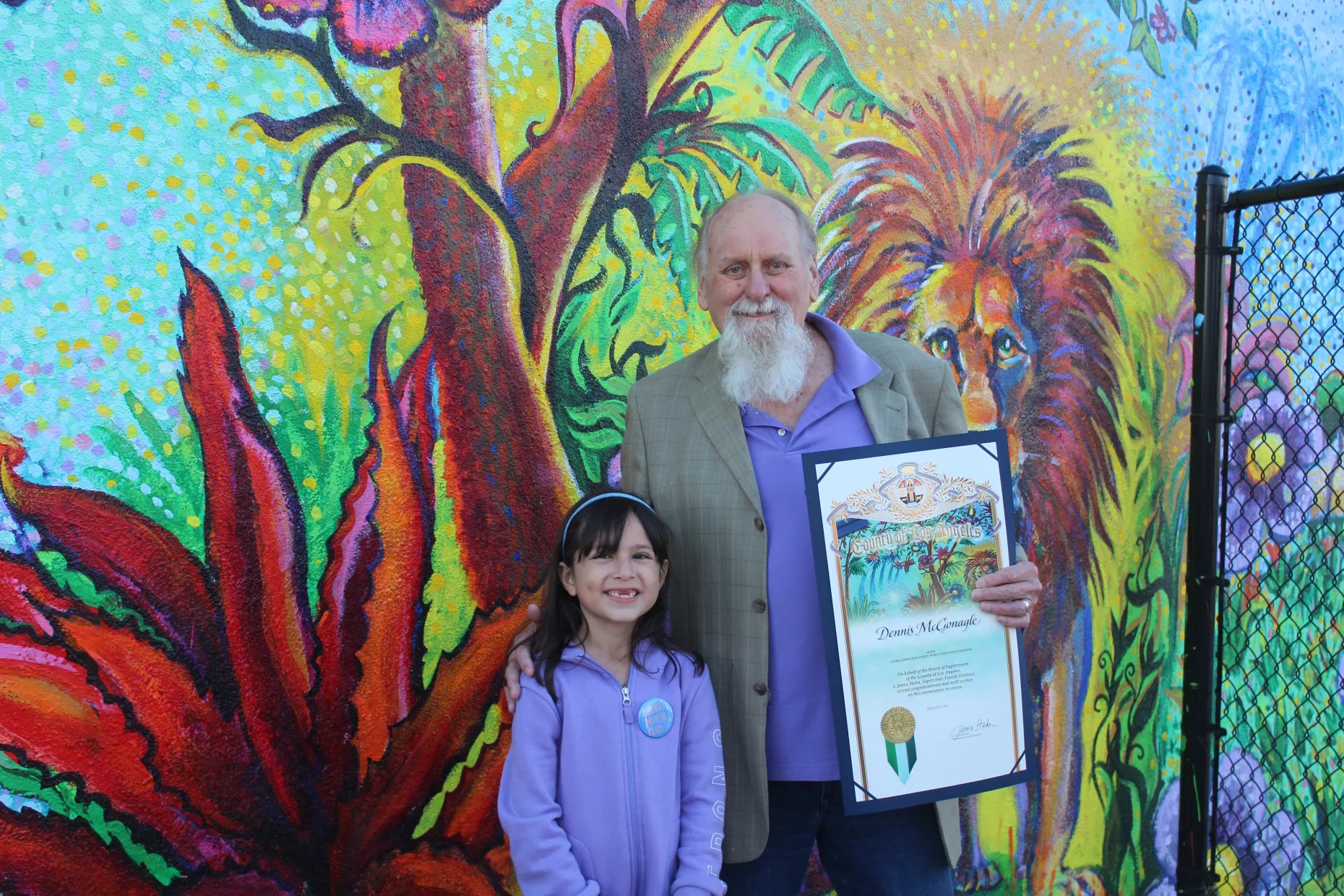 Dennis McGonagle and young girl standing in front of mural at Laurel Elementary School